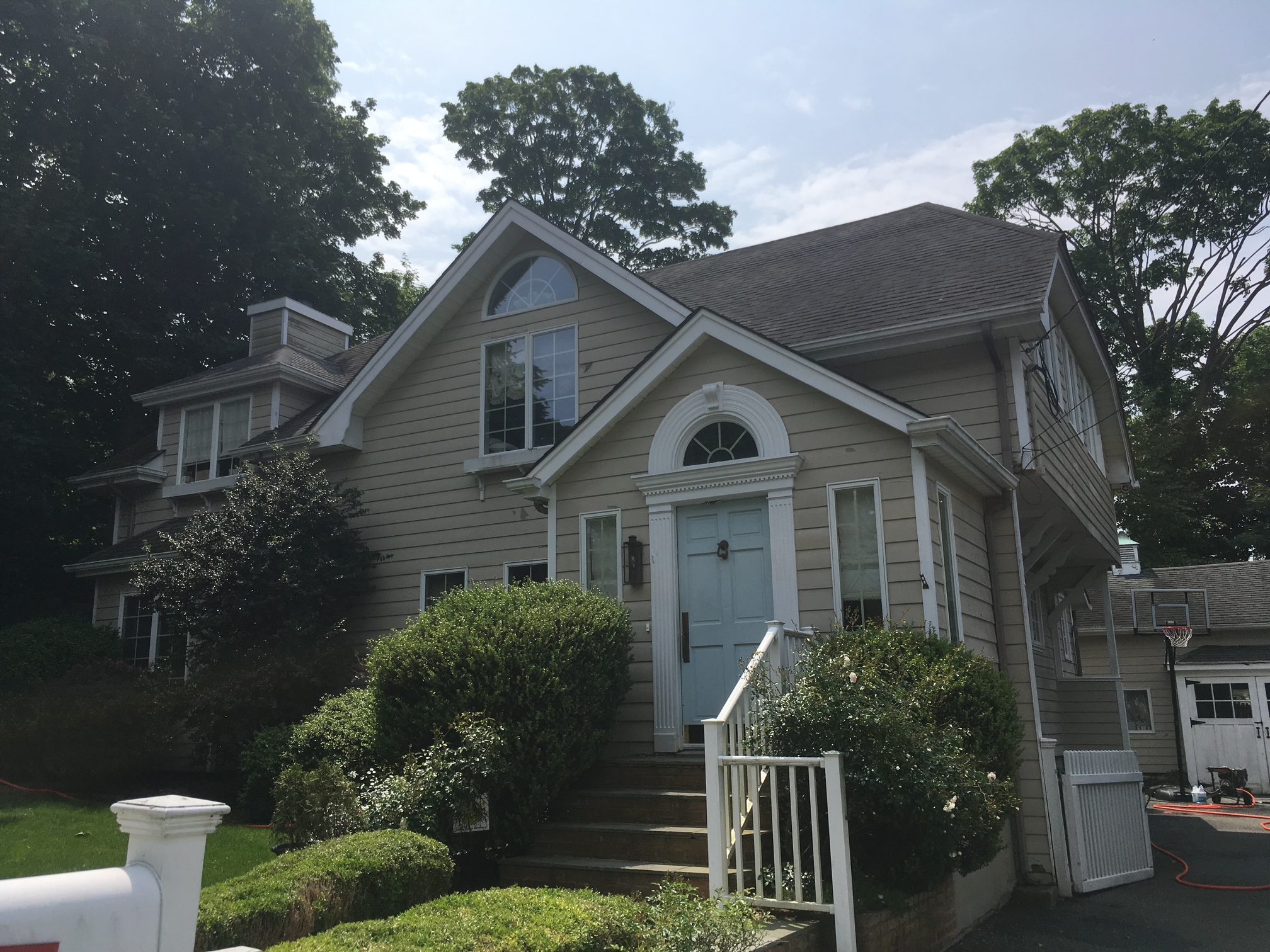 Beige two-story suburban house with front steps
