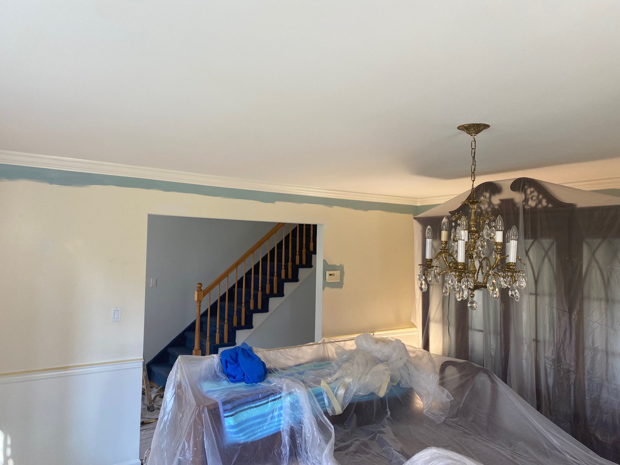 Dining room with chandelier and covered furniture