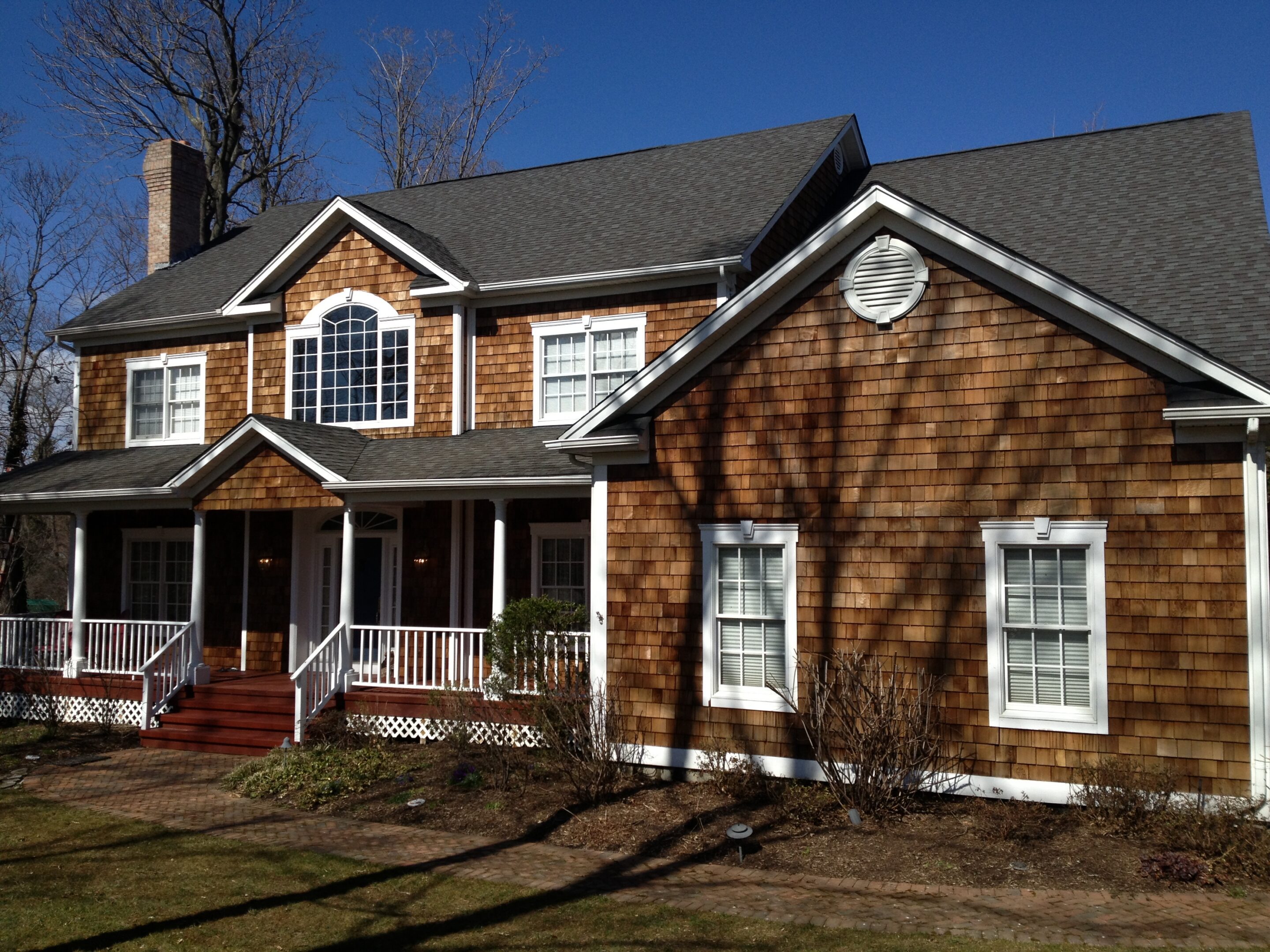 Two-story brown shingle house with front porch