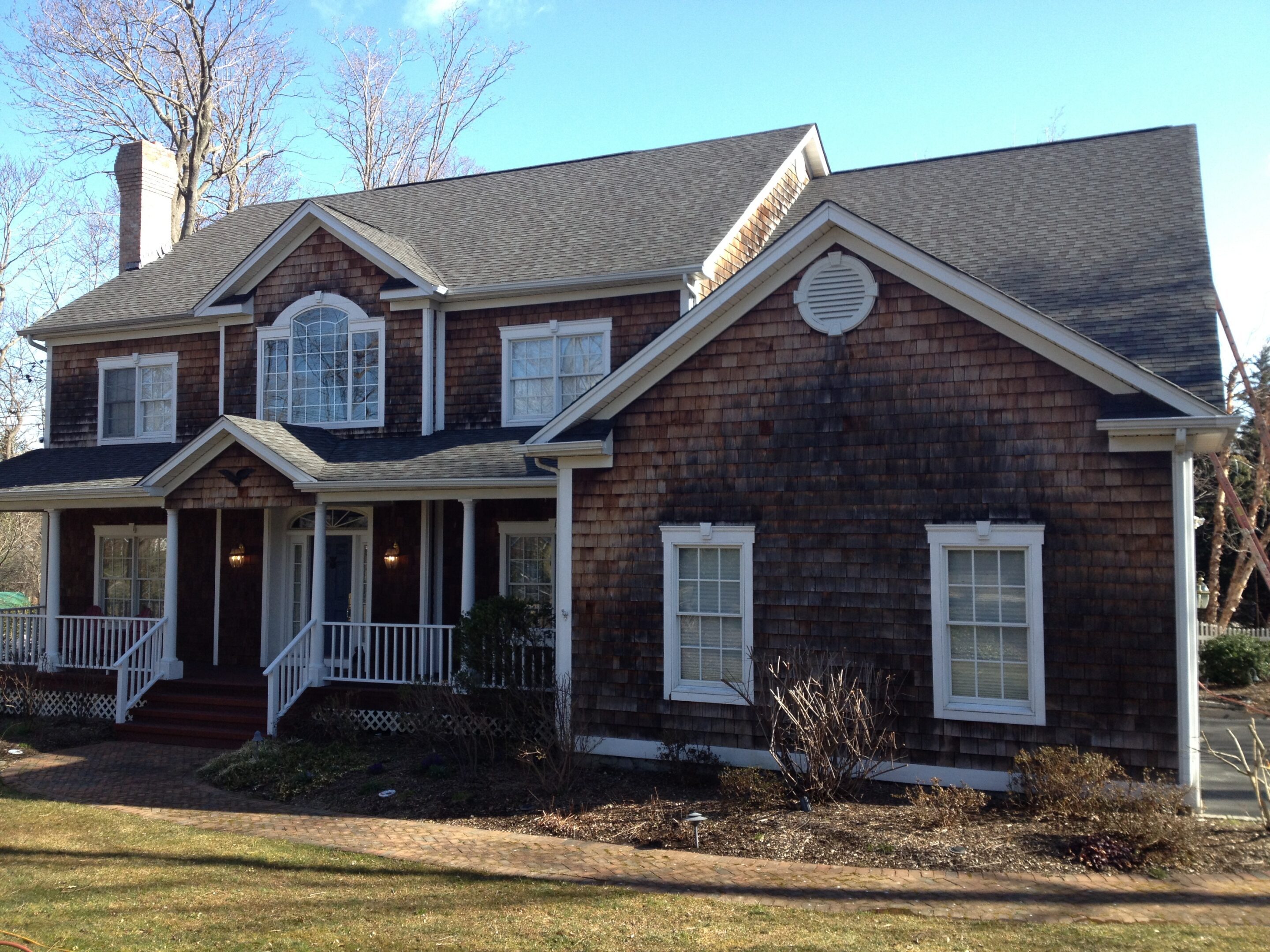 Two-story brown shingle house with porch