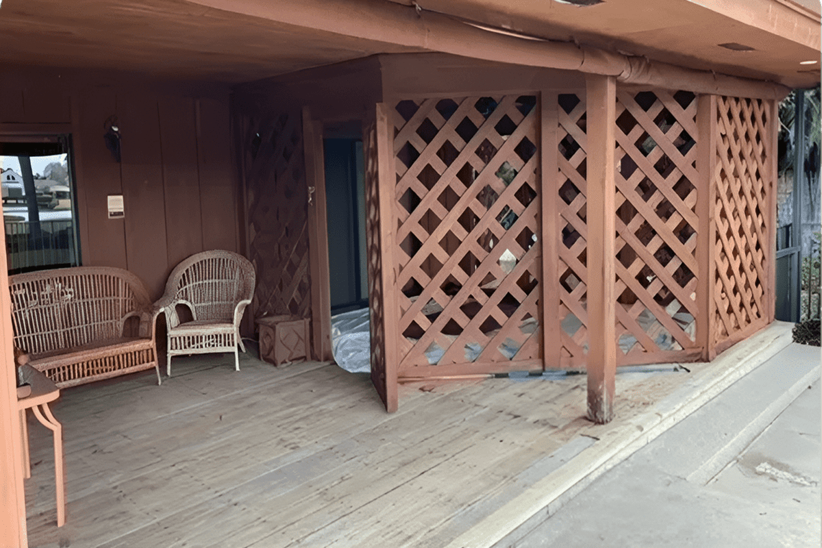Covered wooden porch with lattice and wicker chairs