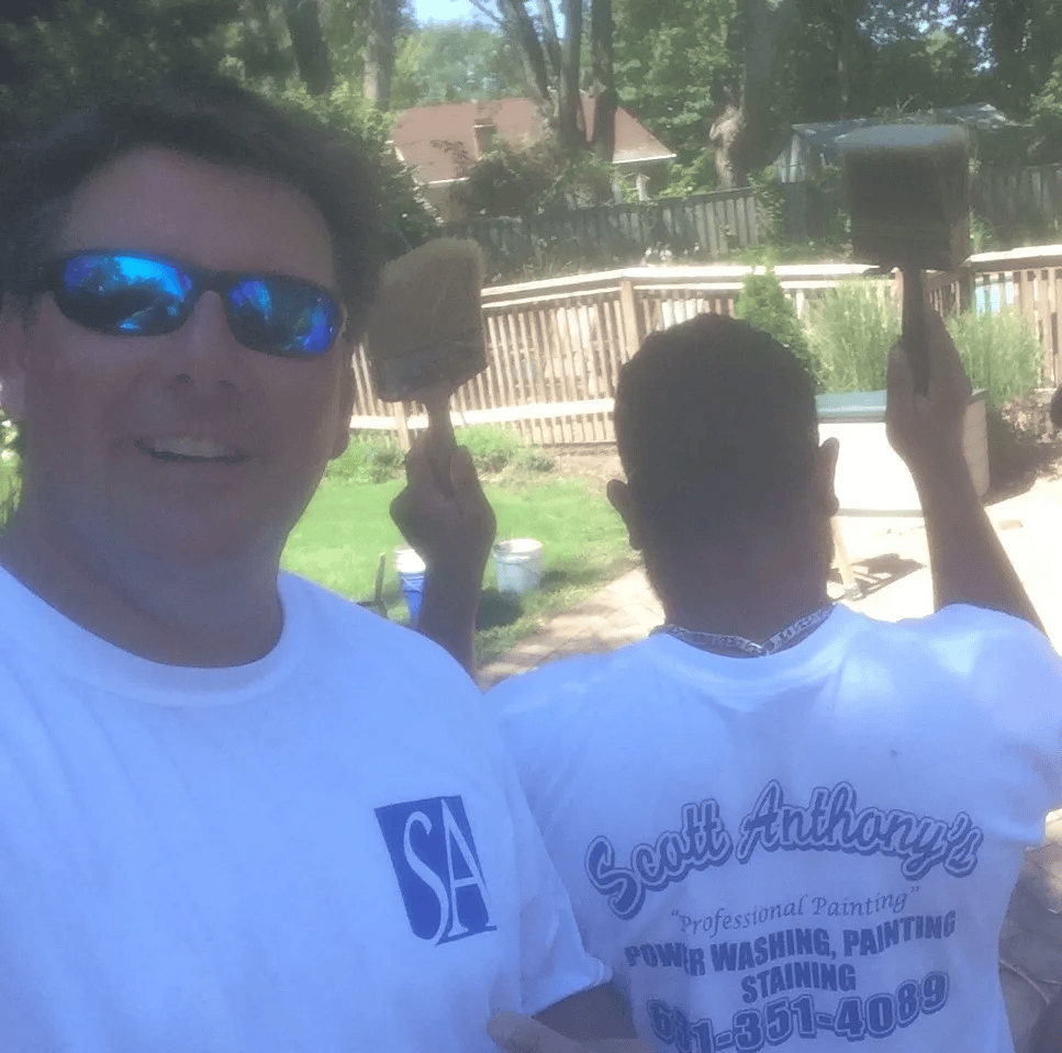 Two painters in white shirts by backyard pool